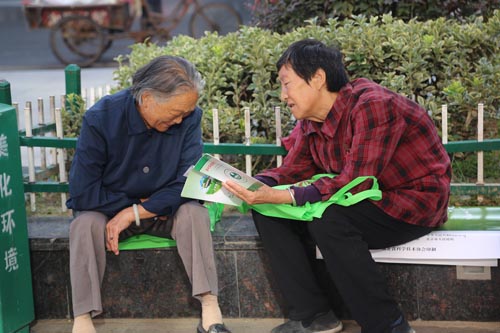 两位老人正在看宣传册并讨论