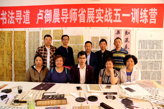卢御晨(左一)为学员授课.卢御晨(左一)为学员示范书写.